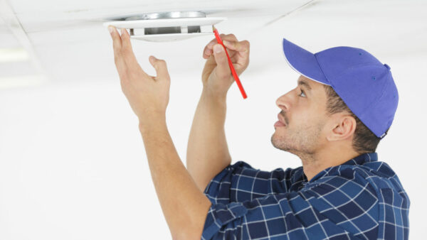 workman marking a spot with pencil to drill a hole